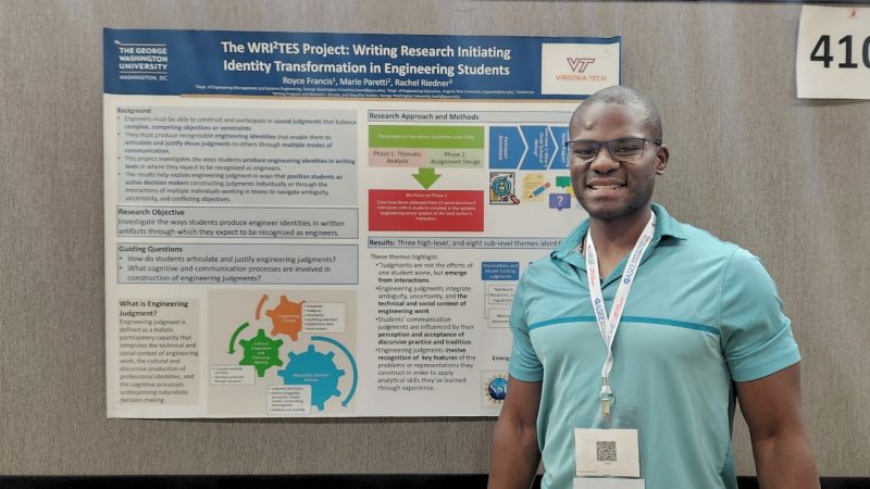 Royce Francis stands in front of his research poster.